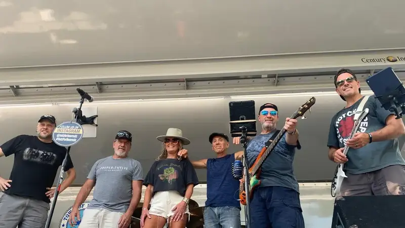 Beer Nutz band members posing together on an outdoor stage with their instruments