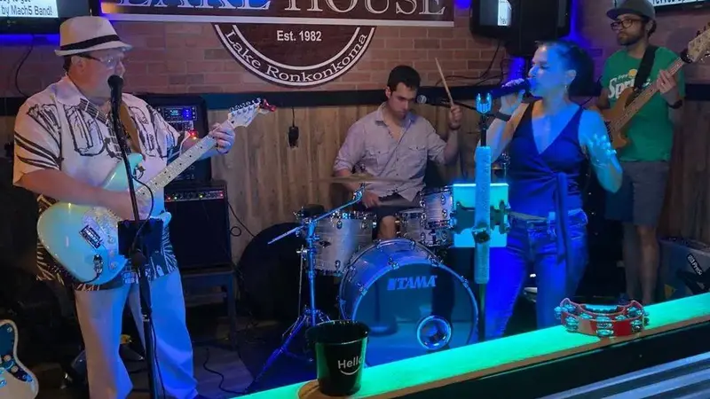 Mach5 playing under blue lights at the Lake House in Lake Ronkonkoma, with a guitarist, drummer and singer