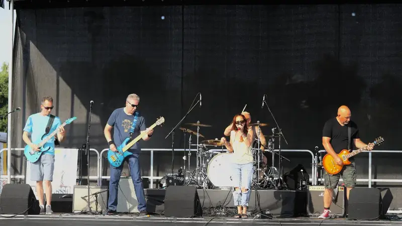 Miss Mayhem performing on a large outdoor festival stage in daylight