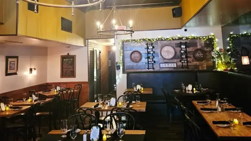 The dining room with set tables, a pressed-tin ceiling and candle-style chandeliers