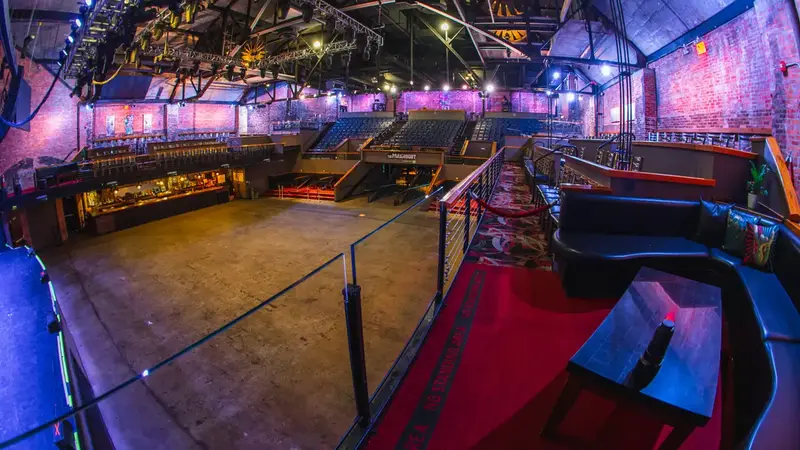 Wide view of The Paramount's empty main floor, a large open standing area surrounded by bars, railings and balcony seating