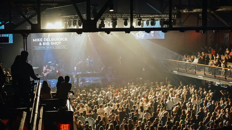 A packed main floor watching a Billy Joel tribute band on The Paramount's stage under bright stage lights