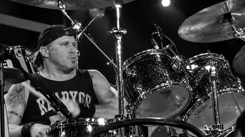 Black-and-white photo of Radio Active's drummer playing a drum kit on stage