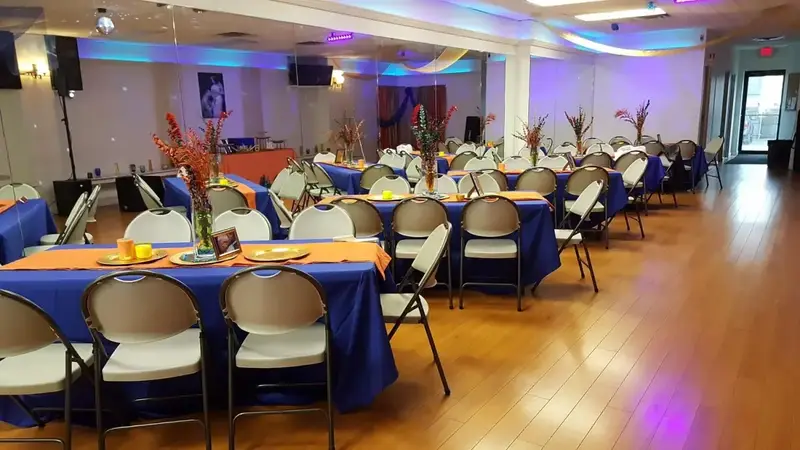 The studio room with purple lighting, mirrors and tables with blue and orange cloths on a light wood floor