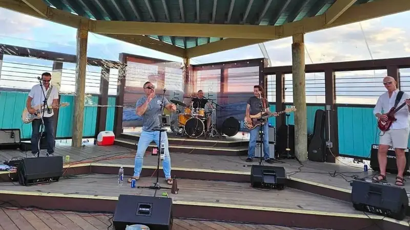 The Byrne Unit playing on a covered outdoor waterfront stage on a summer evening