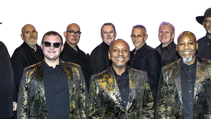 Group promo photo of the ten members of The Soul Jam Revue in black shirts, the three front singers in gold-patterned jackets
